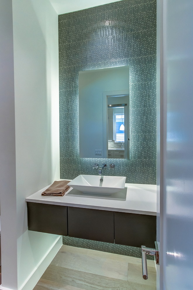 Example of a mid-sized trendy blue tile, gray tile and metal tile light wood floor and brown floor powder room design in Atlanta with flat-panel cabinets, dark wood cabinets, white walls, a vessel sink and quartz countertops