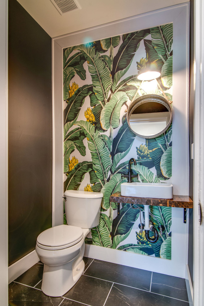 Immagine di un bagno di servizio minimal con pareti multicolore, lavabo a bacinella, top in legno, pavimento nero e top marrone