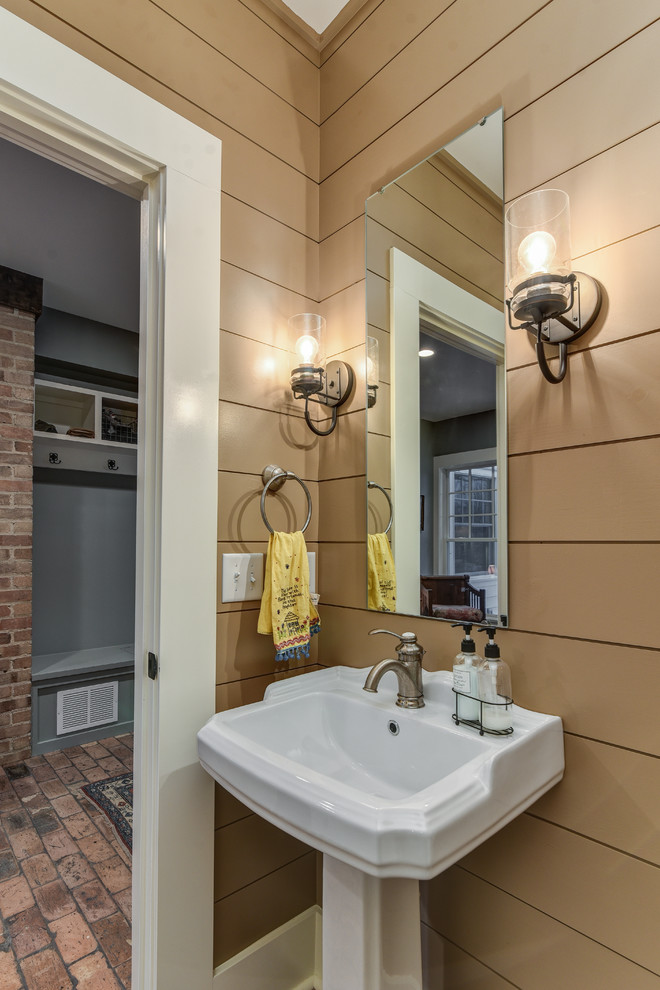 Photo of a small farmhouse cloakroom in Other with beige walls, brick flooring and a pedestal sink.