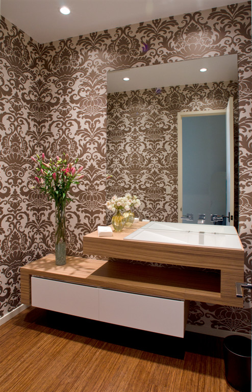 На фото: большой туалет в современном стиле с разноцветными стенами, полом из бамбука, монолитной раковиной и столешницей из дерева с