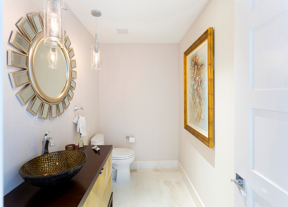 Inspiration for a medium sized contemporary cloakroom in Other with recessed-panel cabinets, yellow cabinets, a one-piece toilet, beige walls, porcelain flooring, a vessel sink, solid surface worktops, beige floors and brown worktops.