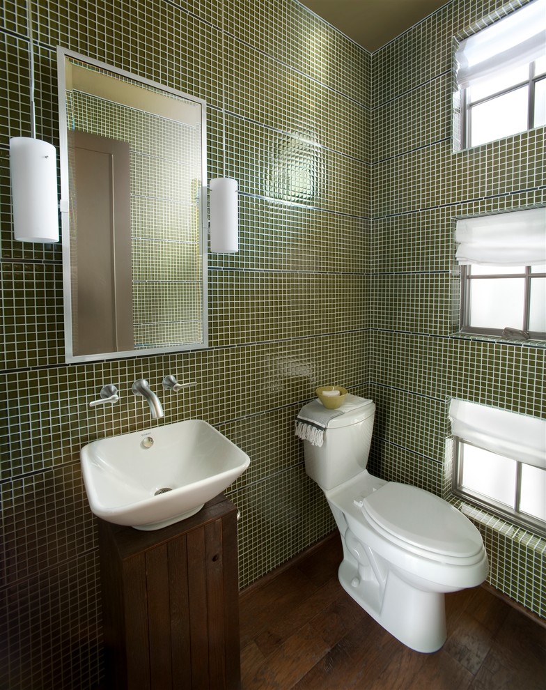 This is an example of a medium sized contemporary cloakroom in Atlanta with a vessel sink, green walls, freestanding cabinets, dark wood cabinets, a one-piece toilet, green tiles, mosaic tiles, dark hardwood flooring and brown floors.