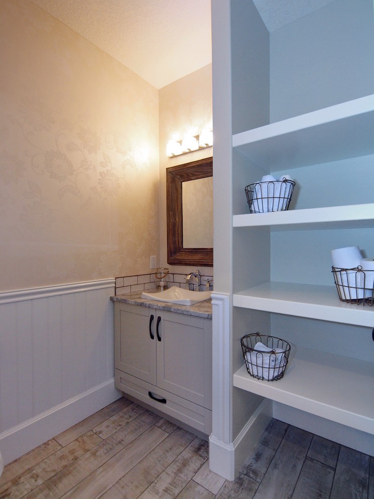 Immagine di un bagno di servizio tradizionale con ante in stile shaker, ante grigie, top in granito, WC monopezzo, lavabo a bacinella e pavimento con piastrelle in ceramica
