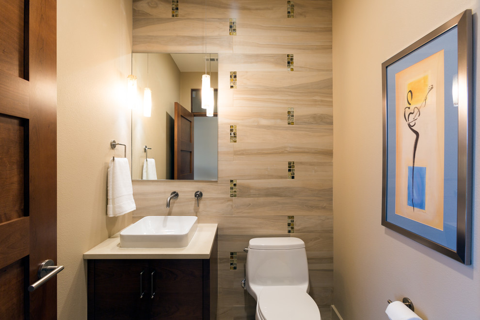 Small trendy multicolored tile and porcelain tile porcelain tile powder room photo in Austin with a vessel sink, flat-panel cabinets, medium tone wood cabinets, a one-piece toilet and beige walls