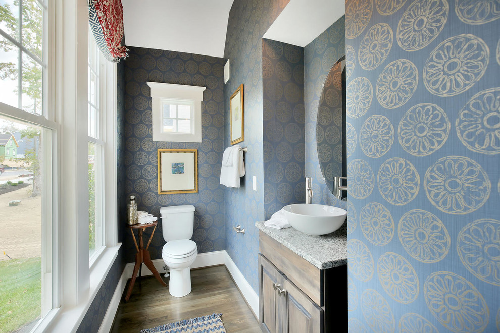 Exempel på ett mellanstort klassiskt toalett, med luckor med upphöjd panel, skåp i mörkt trä, en toalettstol med separat cisternkåpa, blå väggar, mörkt trägolv, ett fristående handfat, granitbänkskiva och brunt golv