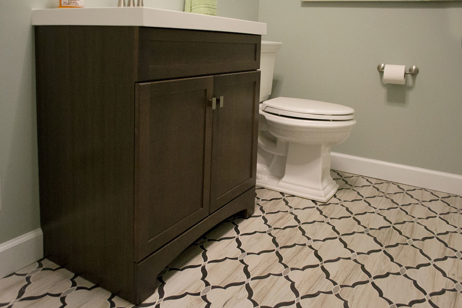 Klassisk inredning av ett litet toalett, med släta luckor, bruna skåp, en toalettstol med hel cisternkåpa, blå väggar, klinkergolv i keramik, ett integrerad handfat, bänkskiva i kvartsit och flerfärgat golv