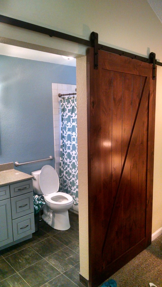This is an example of a small urban cloakroom in Denver with beaded cabinets, blue cabinets, a two-piece toilet, porcelain tiles, blue walls, slate flooring, a submerged sink, engineered stone worktops, black floors and brown worktops.