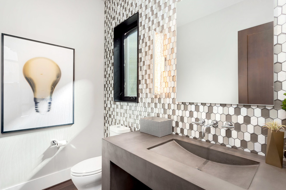 Пример оригинального дизайна: туалет среднего размера в современном стиле с раздельным унитазом, серой плиткой, серыми стенами, паркетным полом среднего тона, монолитной раковиной, столешницей из бетона и коричневым полом
