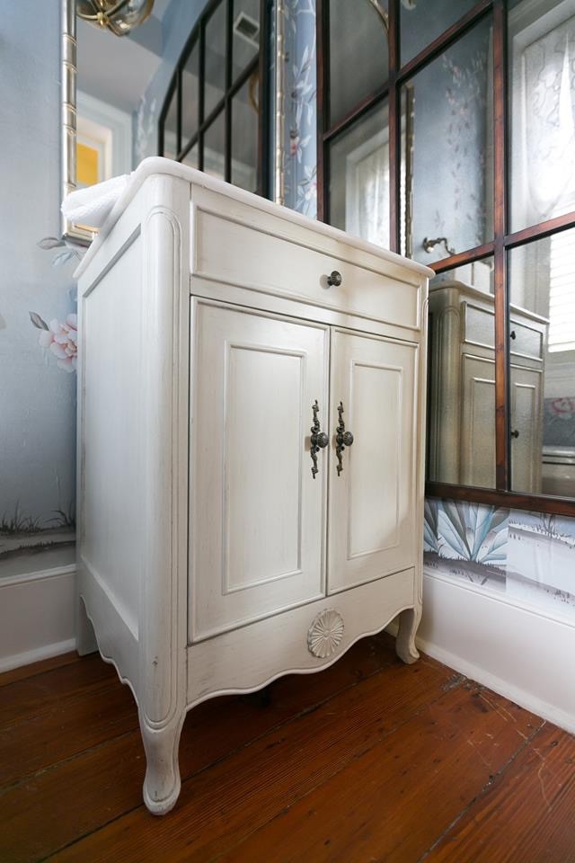 This is an example of a small traditional cloakroom in Charleston with freestanding cabinets, grey cabinets, blue walls, dark hardwood flooring, a submerged sink, marble worktops, brown floors and white worktops.
