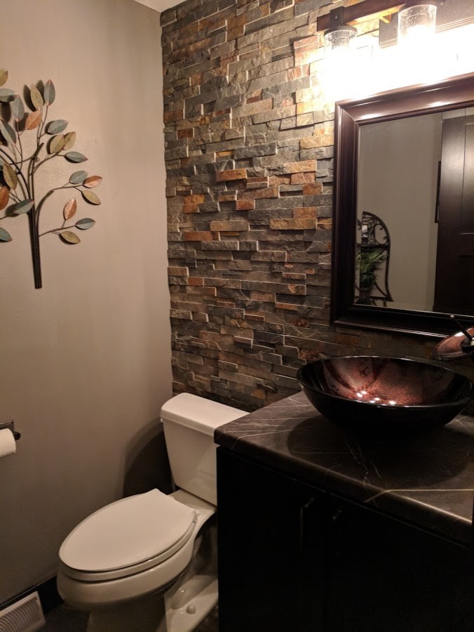 Exempel på ett mellanstort klassiskt toalett, med en toalettstol med separat cisternkåpa, flerfärgad kakel, stenkakel, bruna väggar och ett fristående handfat
