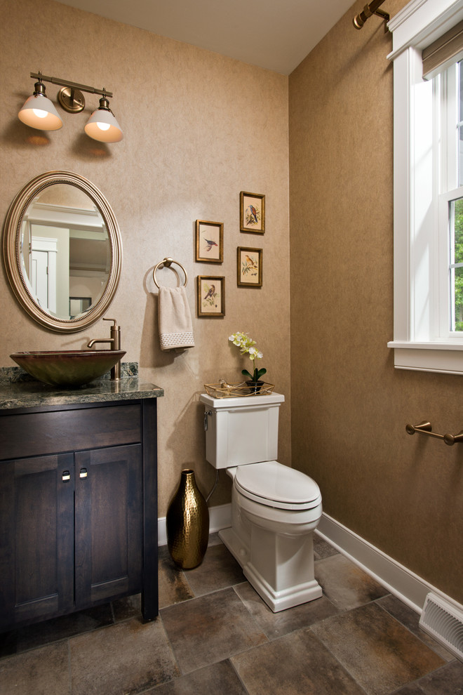 Example of a classic brown floor powder room design in Other with shaker cabinets, dark wood cabinets, brown walls, a vessel sink and gray countertops
