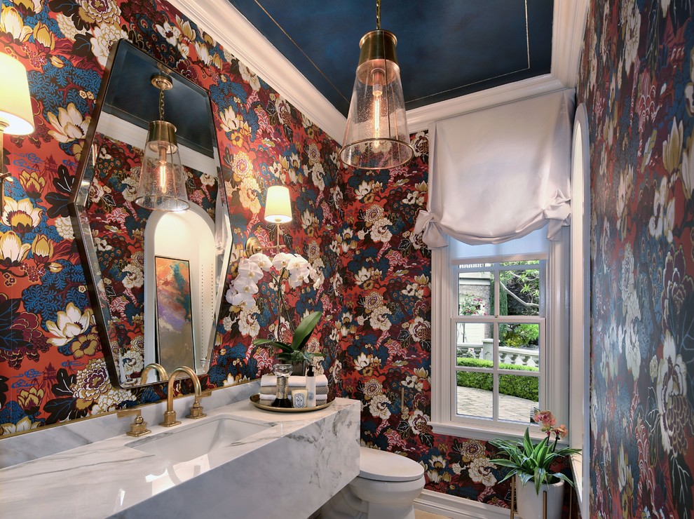 Immagine di un bagno di servizio chic di medie dimensioni con pareti multicolore, pavimento in pietra calcarea, lavabo sottopiano, pavimento beige e top bianco