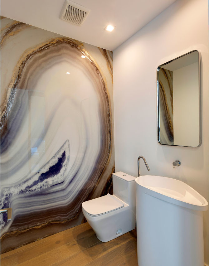 Пример оригинального дизайна: туалет среднего размера в современном стиле с унитазом-моноблоком, разноцветной плиткой, плиткой из листового камня, белыми стенами, паркетным полом среднего тона, раковиной с пьедесталом, столешницей из искусственного камня, бежевым полом и белой столешницей