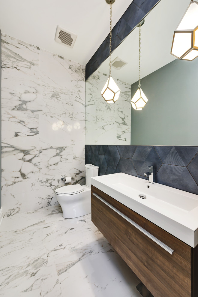 Ispirazione per un bagno di servizio design con ante lisce, WC a due pezzi, piastrelle blu, pareti blu e lavabo sospeso