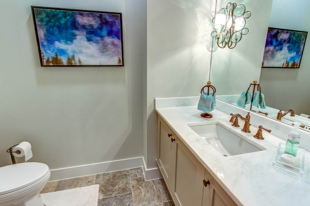 Powder room - mid-sized transitional stone tile travertine floor and brown floor powder room idea in Atlanta with shaker cabinets, marble countertops, beige cabinets, gray walls and an undermount sink