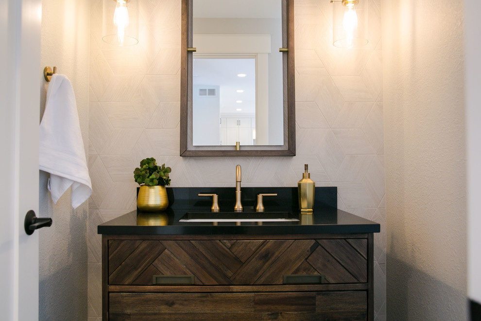 Photo of a medium sized classic cloakroom in Denver with flat-panel cabinets, dark wood cabinets, a one-piece toilet, grey tiles, travertine tiles, a submerged sink, engineered stone worktops and black worktops.
