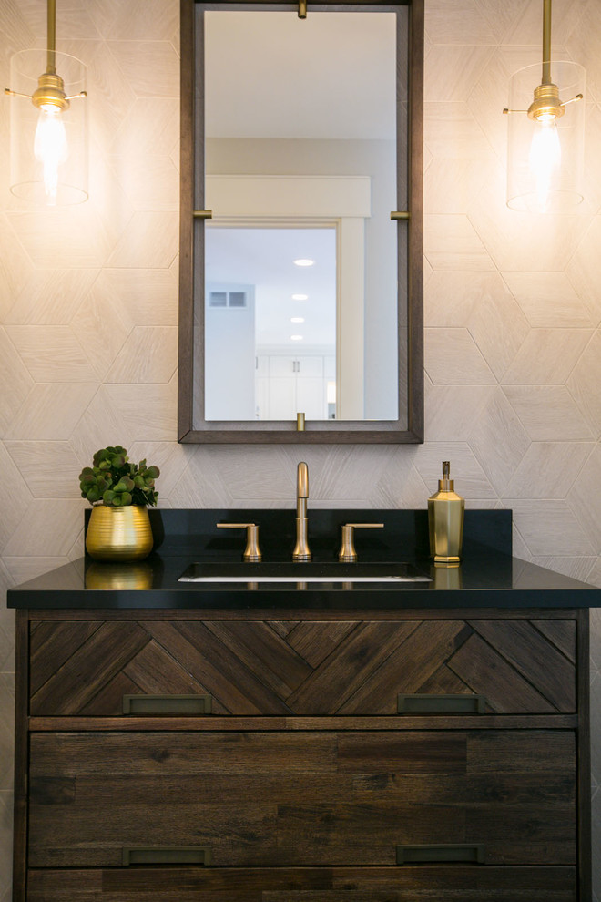 This is an example of a medium sized traditional cloakroom in Denver with flat-panel cabinets, dark wood cabinets, a one-piece toilet, grey tiles, travertine tiles, a submerged sink, engineered stone worktops and black worktops.