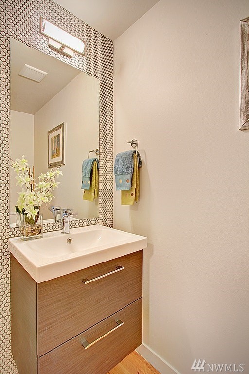 Immagine di un bagno di servizio minimalista con ante lisce, ante in legno scuro, piastrelle bianche, piastrelle a mosaico, pavimento in legno massello medio, lavabo a consolle e pavimento grigio