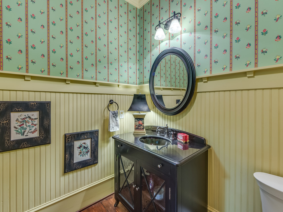 Idée de décoration pour un WC et toilettes champêtre en bois foncé avec un lavabo encastré, un mur multicolore, parquet foncé et un placard à porte vitrée.
