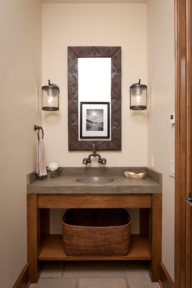 Exempel på ett litet klassiskt toalett, med beige väggar, ett piedestal handfat, bänkskiva i betong, öppna hyllor, skåp i mellenmörkt trä och stenhäll