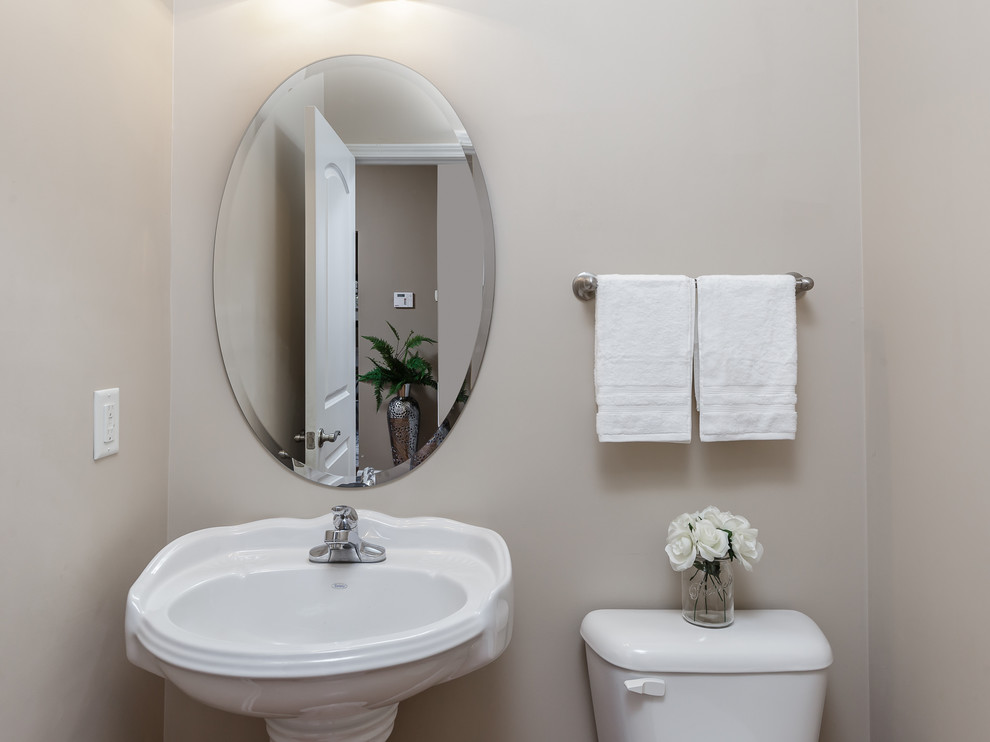 Foto di un piccolo bagno di servizio stile americano con WC monopezzo, piastrelle beige, pareti beige, pavimento in cementine, lavabo a colonna e pavimento beige
