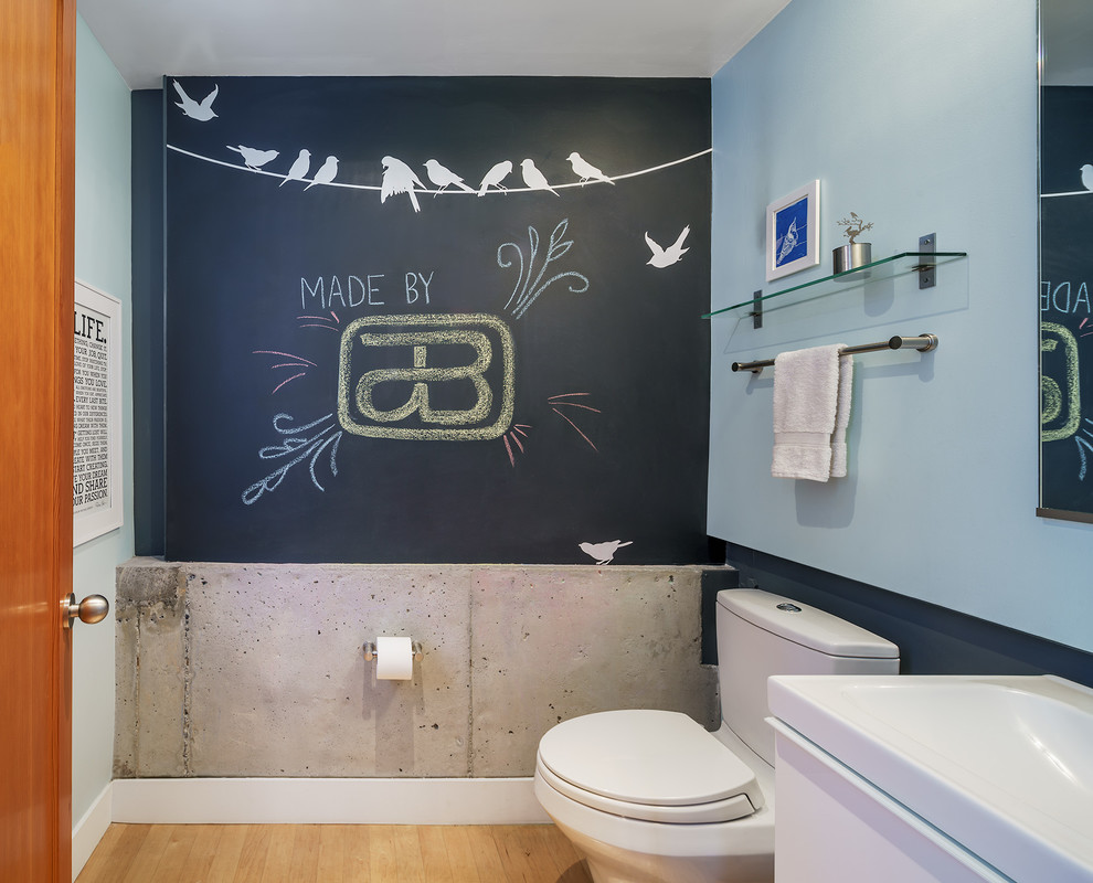 Immagine di un piccolo bagno di servizio industriale con ante lisce, ante bianche, WC a due pezzi, pareti blu, parquet chiaro, lavabo a bacinella, top in legno, pavimento beige e top bianco