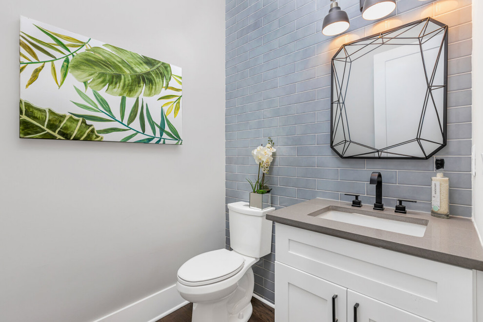 This is an example of a medium sized classic cloakroom in Atlanta with shaker cabinets, white cabinets, a two-piece toilet, blue tiles, ceramic tiles, white walls, light hardwood flooring, a submerged sink, quartz worktops, brown floors and grey worktops.