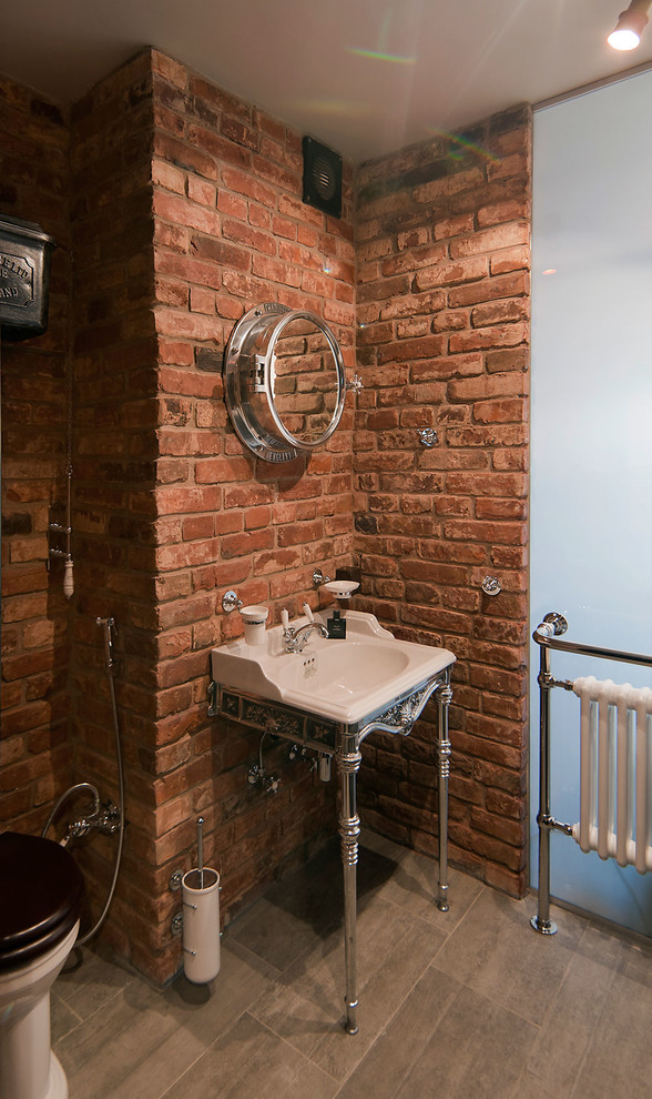 Foto på ett industriellt toalett, med en toalettstol med separat cisternkåpa och ett konsol handfat