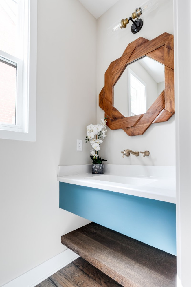 Foto di un bagno di servizio minimalista di medie dimensioni con WC monopezzo, pareti beige, pavimento in legno massello medio, lavabo sospeso, top in marmo, pavimento marrone e top bianco