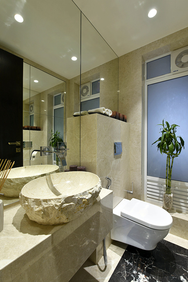 Aménagement d'un petit WC suspendu contemporain avec un placard à porte plane, un carrelage beige, un mur beige, un sol en marbre, un plan de toilette en marbre, une vasque et du carrelage en marbre.