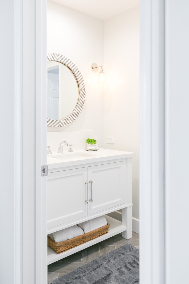 This is an example of a medium sized nautical cloakroom in Los Angeles with white cabinets, ceramic tiles, white walls, ceramic flooring, a submerged sink, engineered stone worktops, recessed-panel cabinets and grey tiles.