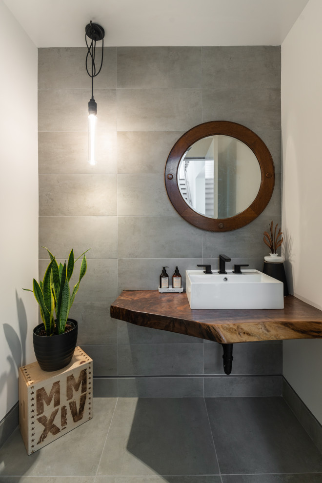 Design ideas for a medium sized contemporary cloakroom in Los Angeles with open cabinets, grey tiles, porcelain tiles, white walls, porcelain flooring, a vessel sink, wooden worktops, grey floors, brown worktops and a floating vanity unit.