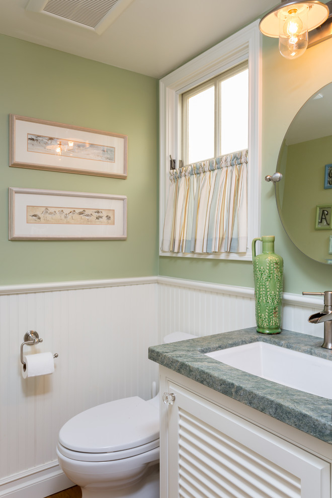 Idée de décoration pour un petit WC et toilettes marin avec un placard à porte affleurante, des portes de placard blanches, WC à poser, un carrelage blanc, un mur vert, parquet clair, un plan de toilette en marbre, un sol marron et un plan de toilette gris.