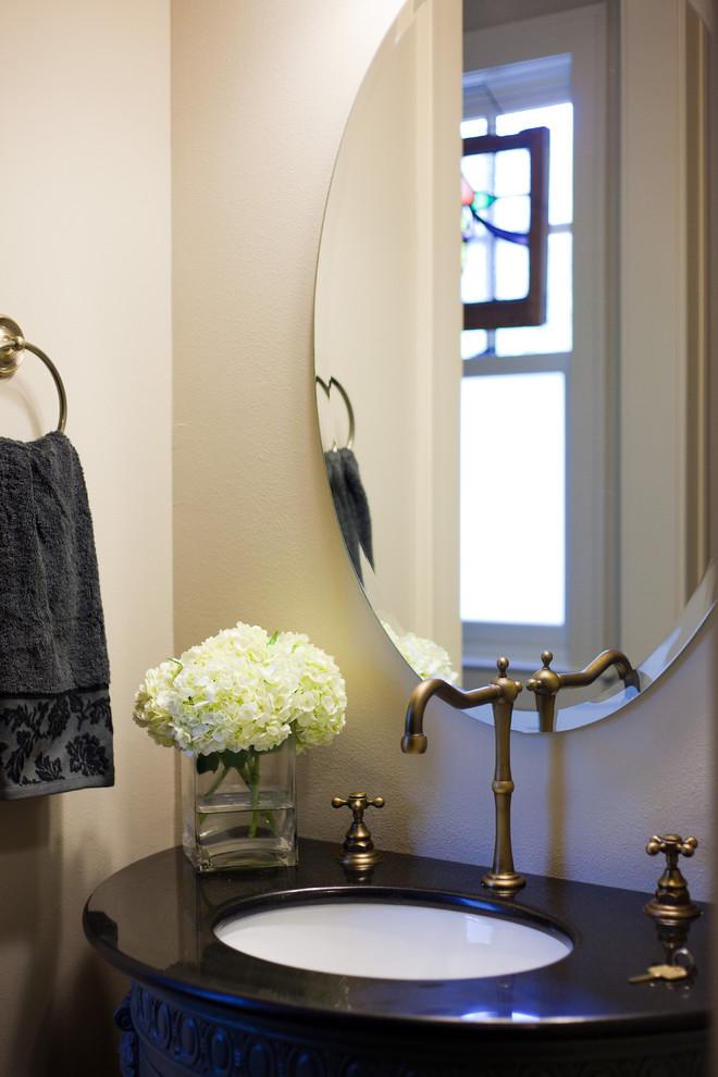 Inspiration for a timeless powder room remodel in Austin with solid surface countertops and black countertops
