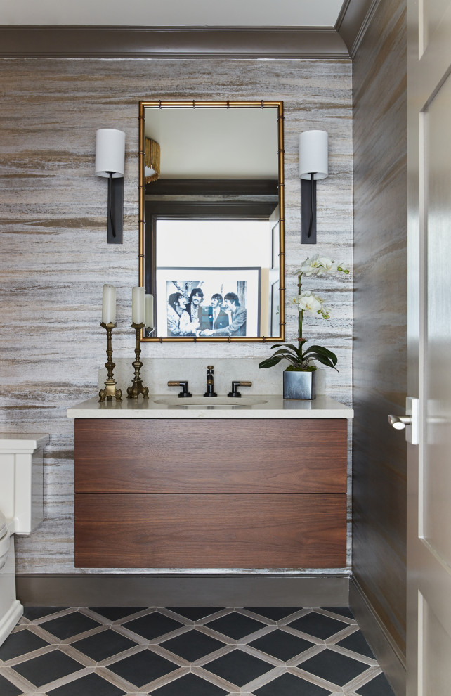 Inspiration for a traditional cloakroom in Nashville with freestanding cabinets, medium wood cabinets, a one-piece toilet, porcelain flooring, a built-in sink, engineered stone worktops, multi-coloured floors, white worktops, a floating vanity unit and wallpapered walls.