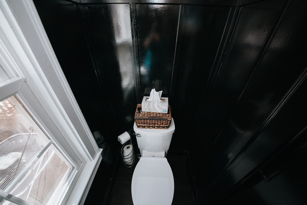 Idee per un piccolo bagno di servizio chic con WC a due pezzi, pareti nere, parquet scuro e pavimento nero