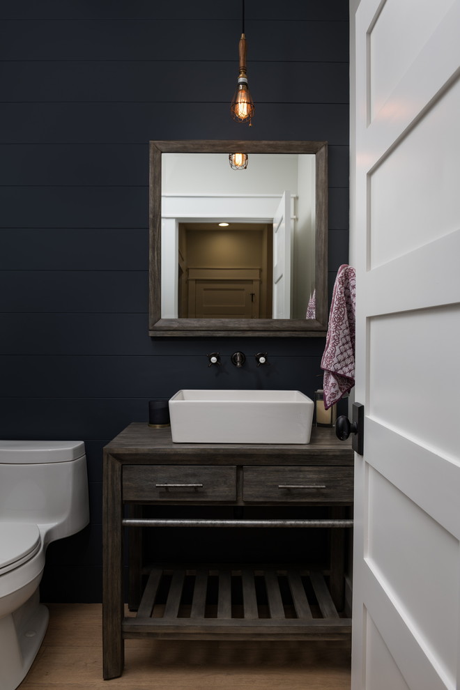 Idéer för lantliga grått toaletter, med släta luckor, grå skåp, blå väggar, mellanmörkt trägolv, ett fristående handfat, träbänkskiva och brunt golv