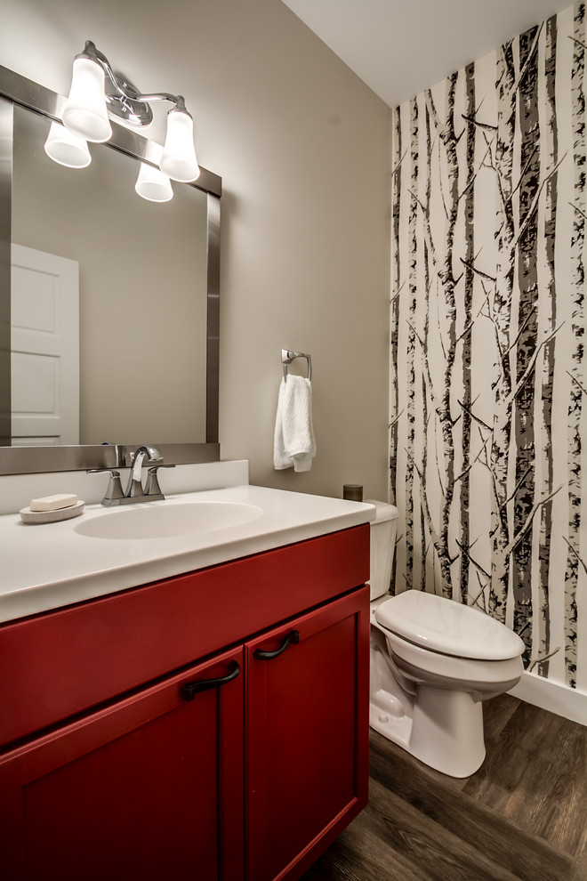 Idéer för ett mellanstort minimalistiskt toalett, med ett integrerad handfat, skåp i shakerstil, röda skåp, bänkskiva i akrylsten, en toalettstol med separat cisternkåpa, grå väggar, vinylgolv och brunt golv