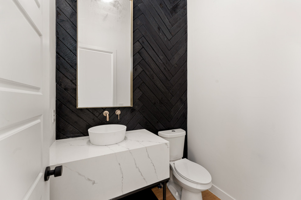Imagen de aseo de pie minimalista con puertas de armario blancas, paredes negras, suelo de madera clara, lavabo sobreencimera, encimera de cuarcita y encimeras blancas