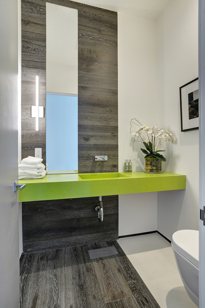 Imagen de aseo actual con lavabo integrado, paredes blancas y suelo de madera oscura