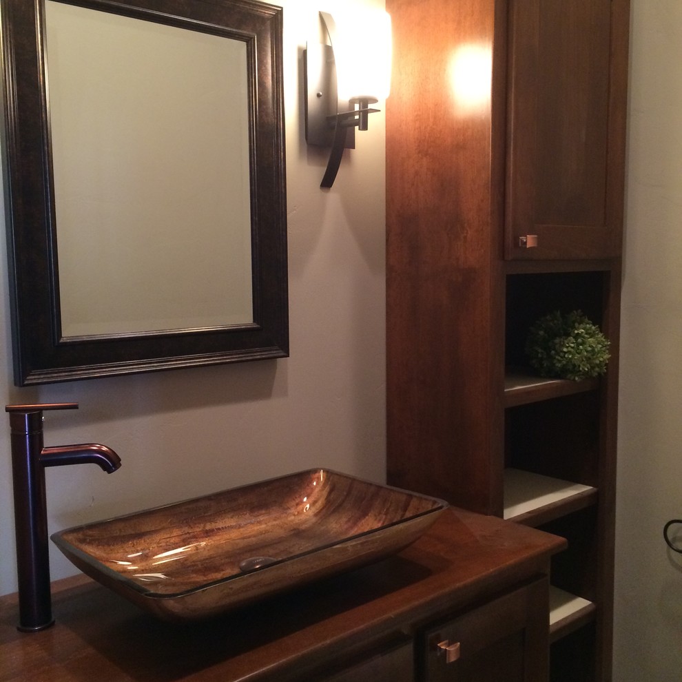 Kleine Urige Gästetoilette mit dunklen Holzschränken, beiger Wandfarbe, Aufsatzwaschbecken, Mineralwerkstoff-Waschtisch und brauner Waschtischplatte in Denver