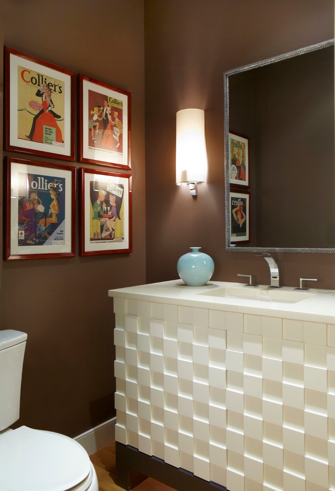 Cette image montre un petit WC et toilettes traditionnel avec un lavabo encastré, des portes de placard blanches, WC séparés, un mur marron et un sol en bois brun.