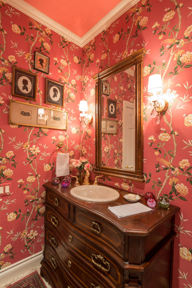 Example of a classic medium tone wood floor powder room design in Other with red walls and a console sink