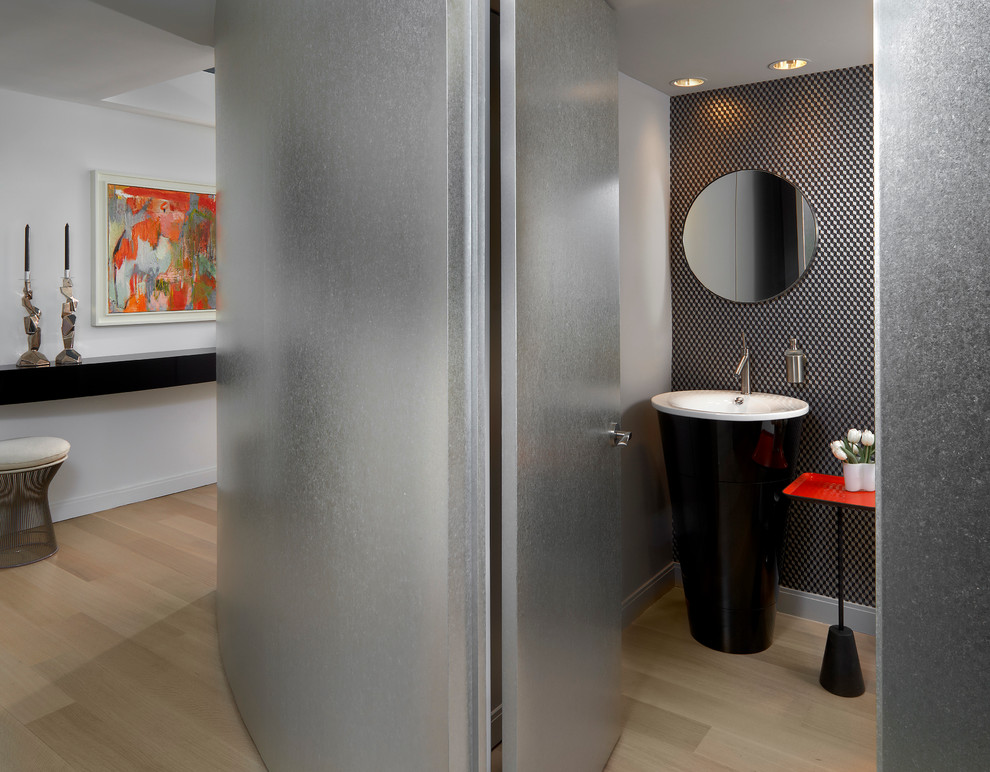 На фото: туалет среднего размера в современном стиле с раковиной с пьедесталом, разноцветными стенами и светлым паркетным полом
