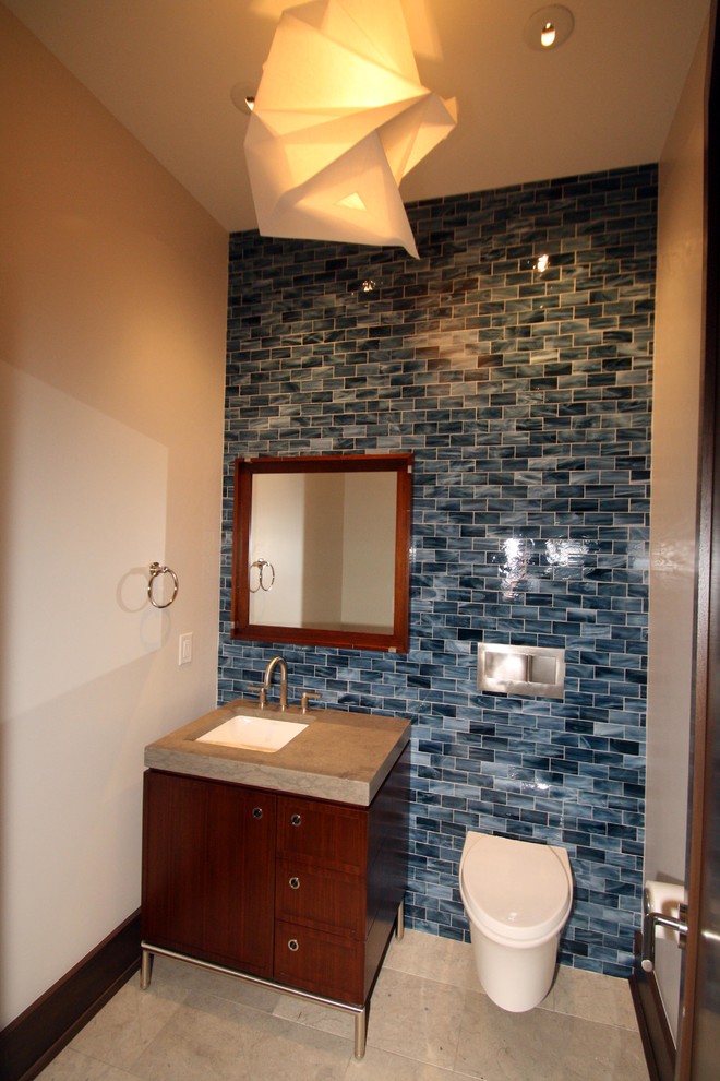 Exemple d'un WC suspendu chic en bois brun de taille moyenne avec un placard à porte plane, un carrelage bleu, du carrelage en marbre, un mur beige, un sol en travertin, un lavabo encastré, un plan de toilette en quartz modifié et un sol beige.