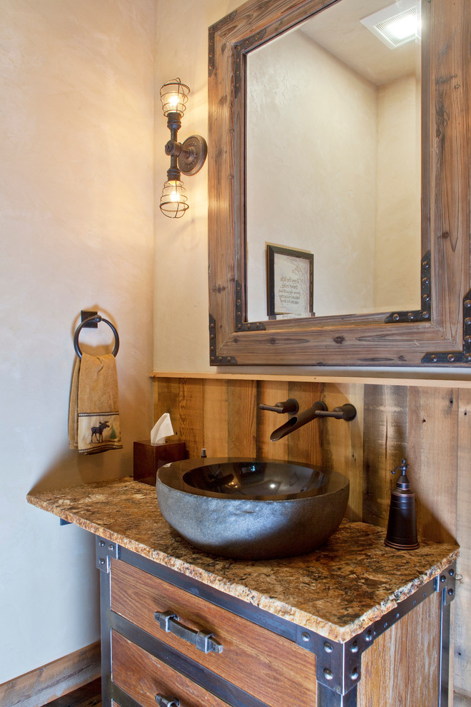 Imagen de aseo rural pequeño con lavabo sobreencimera, armarios con paneles lisos, puertas de armario de madera clara, encimera de granito, paredes beige y suelo de madera en tonos medios
