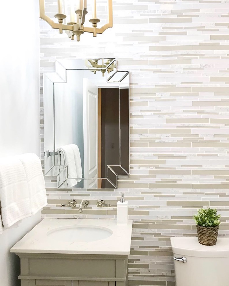 Inspiration for a small traditional cloakroom in DC Metro with recessed-panel cabinets, grey cabinets, a one-piece toilet, multi-coloured tiles, mosaic tiles, white walls, an integrated sink, quartz worktops and grey worktops.