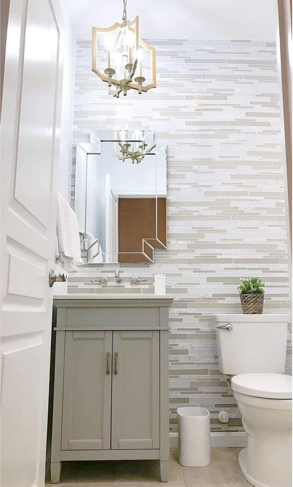 Example of a small transitional multicolored tile and mosaic tile powder room design in DC Metro with raised-panel cabinets, gray cabinets, a one-piece toilet, white walls, an integrated sink, quartzite countertops and multicolored countertops