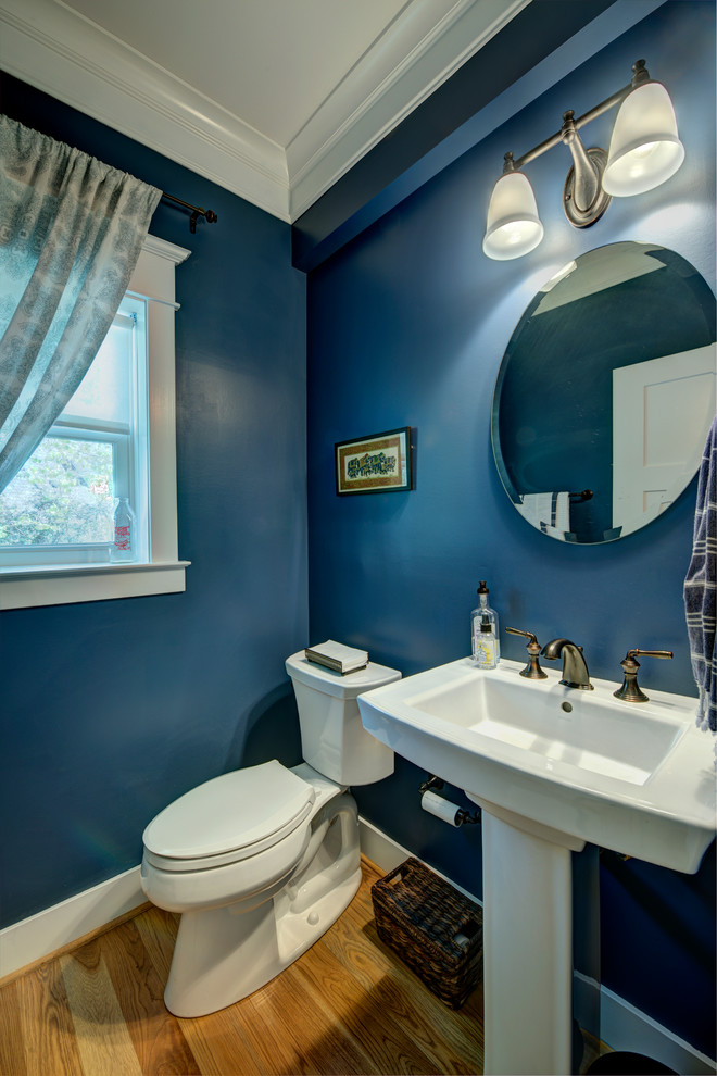 Foto di un piccolo bagno di servizio design con lavabo a colonna, WC monopezzo, pareti blu e parquet chiaro
