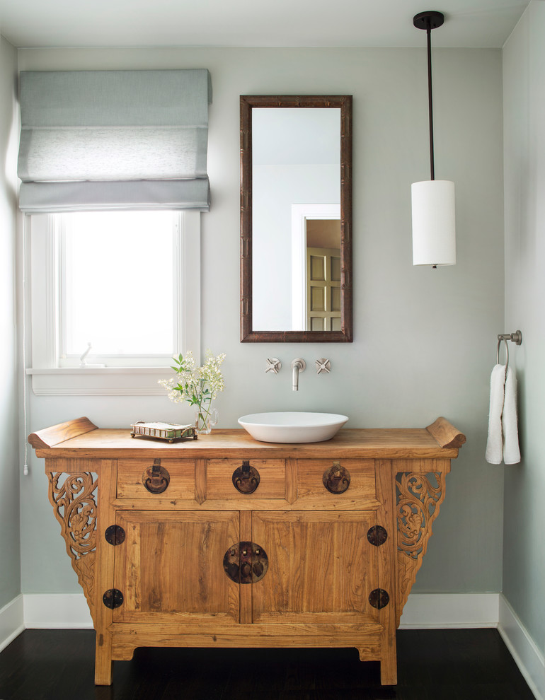 Immagine di un bagno di servizio tradizionale con lavabo a bacinella, consolle stile comò, ante in legno scuro, pareti grigie e parquet scuro